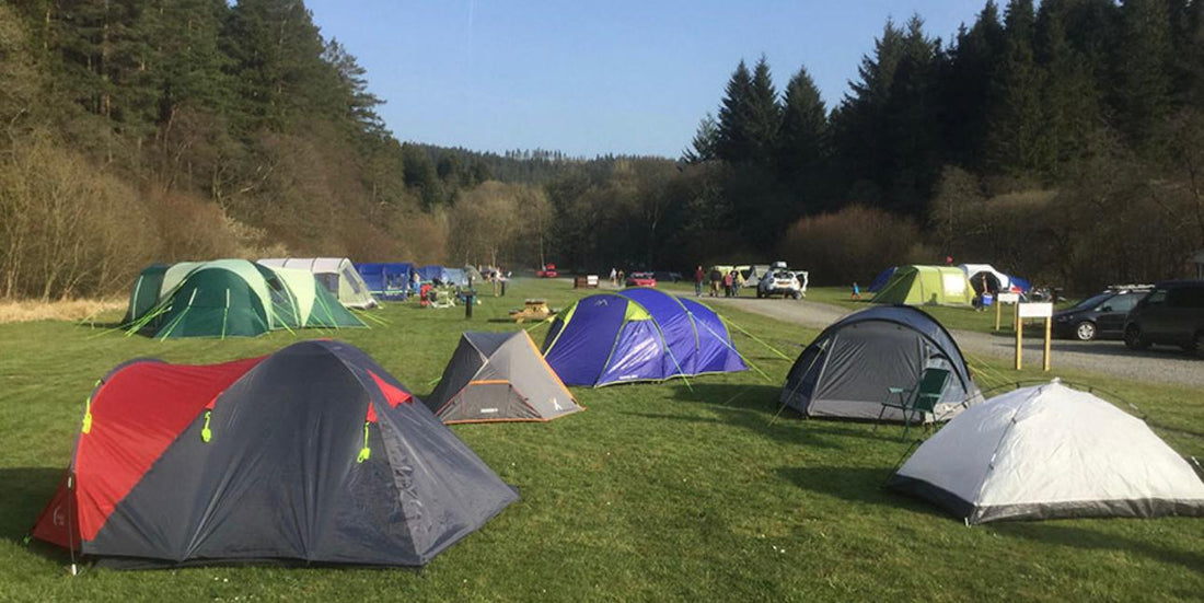 Group of campers with different tent styles pitched in a scenic UK national park